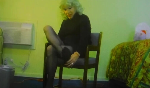 Crossdresser dangles her shoes and poses