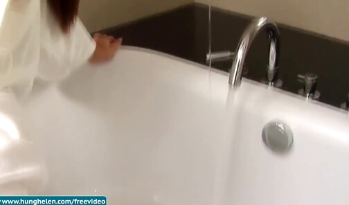 Redhead ladyboy in white bathrobe strokes her big dick in bathtub